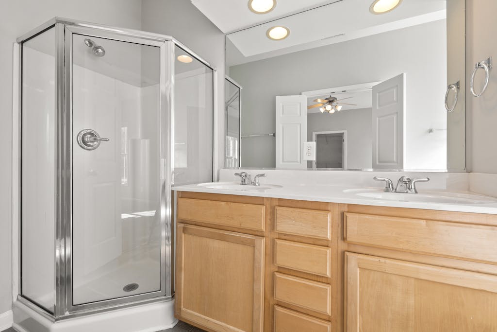 Spacious and bright modern bathroom featuring a double sink vanity and glass shower.