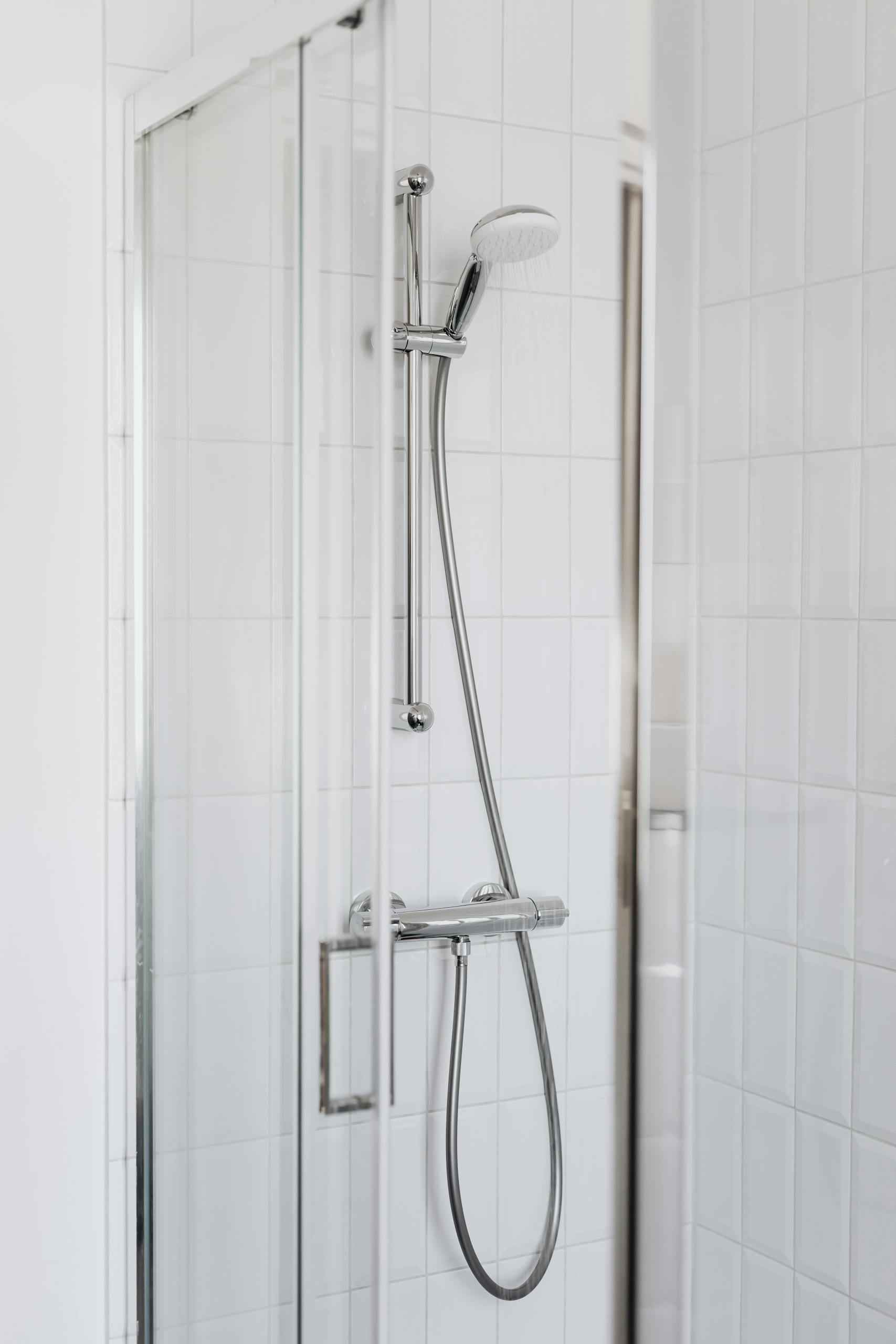 Elegant modern shower with minimalist glass design and stainless steel fixtures.