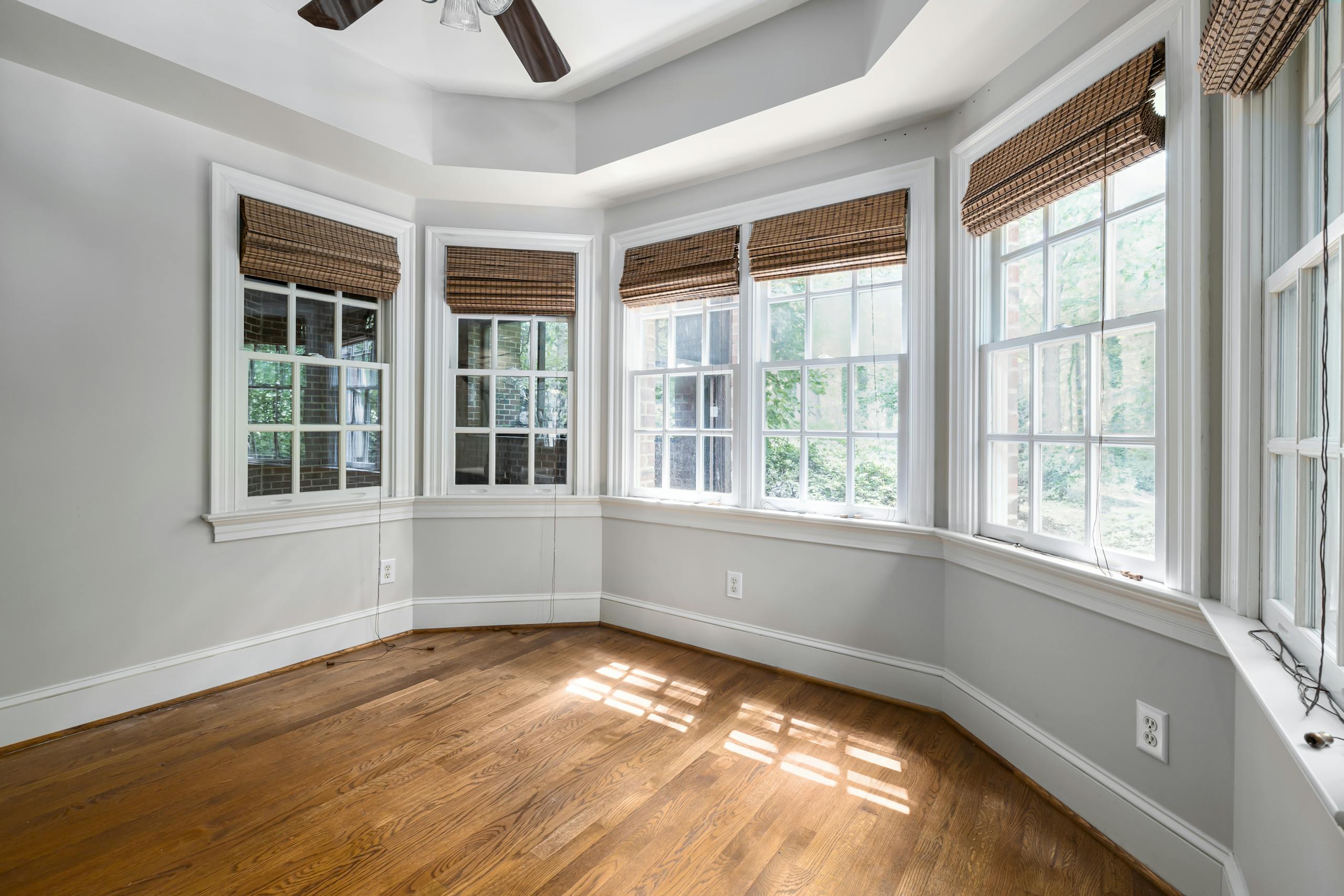 Spacious room with bay windows and wooden floor, perfect for home design inspiration.